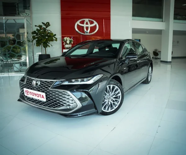 نمای جلو و کناری تویوتا آوالون هیبرید در نمایشگاه رسمی با طراحی لوکس