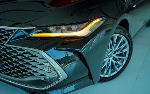 نمای-نزدیک-جلوپنجره-کرومی-و-چراغ-جلوی-تویوتا-آوالون-هیبرید